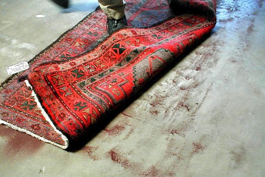 Dust and grit being removed from the back of an Oriental rug