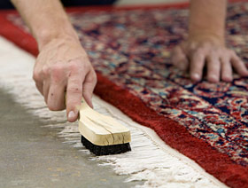 Rug fringe being scrubbed with a brush