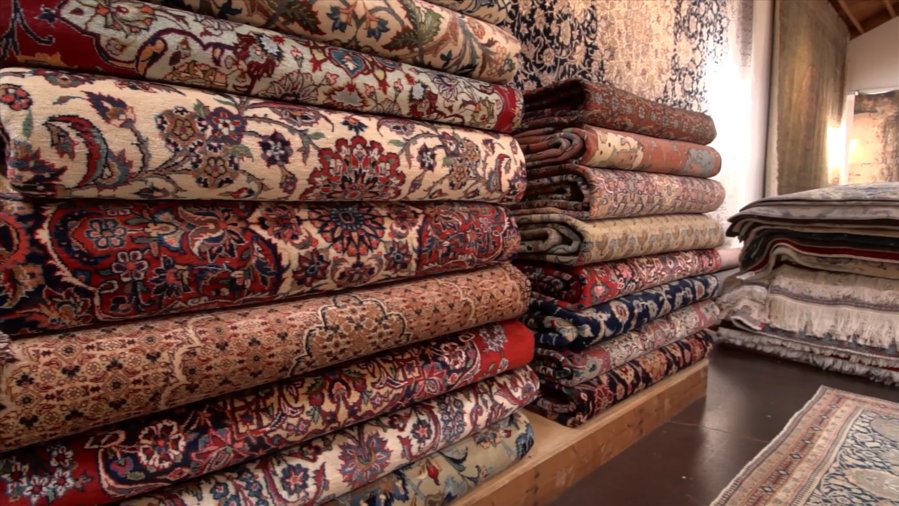 A stack of folded Persian rugs